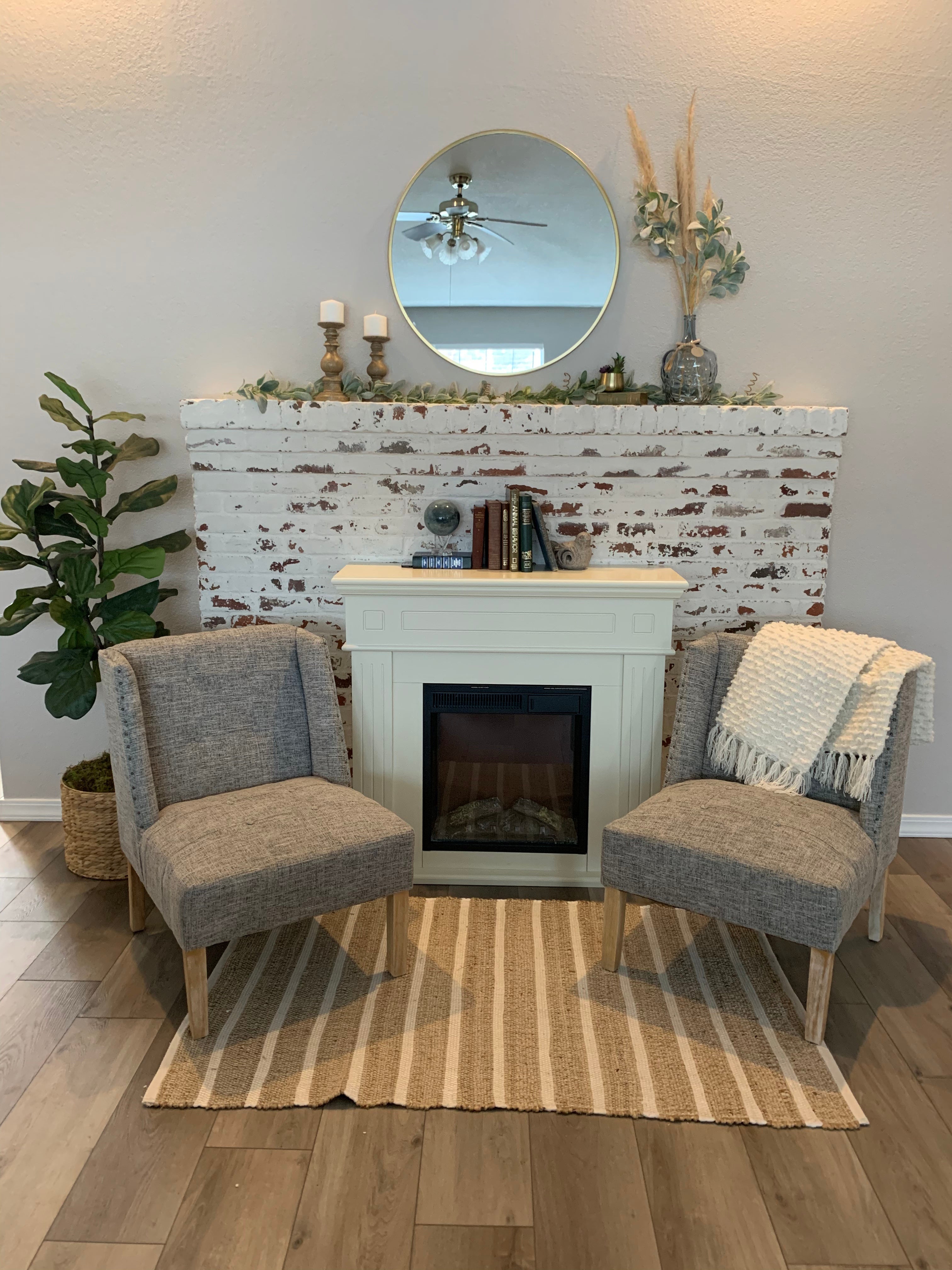 Cozy holiday scene with a glowing electric fireplace, decorated mantle, twinkling lights, a Christmas tree, and wrapped gifts